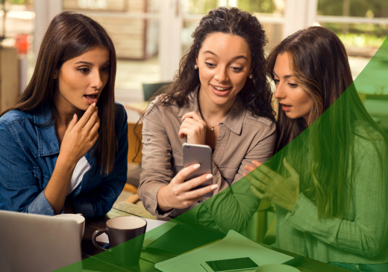 Three girls gossiping around phone