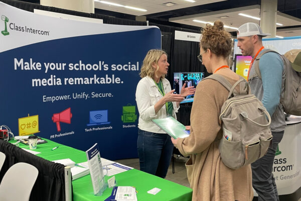 Jill speaking with two teachers at a conference booth