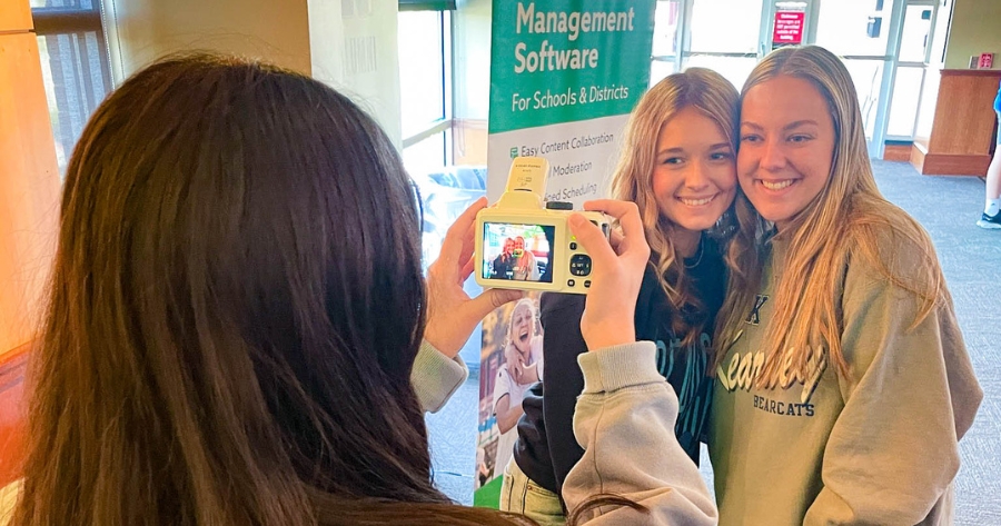 Student taking a photo of two smiling high school students