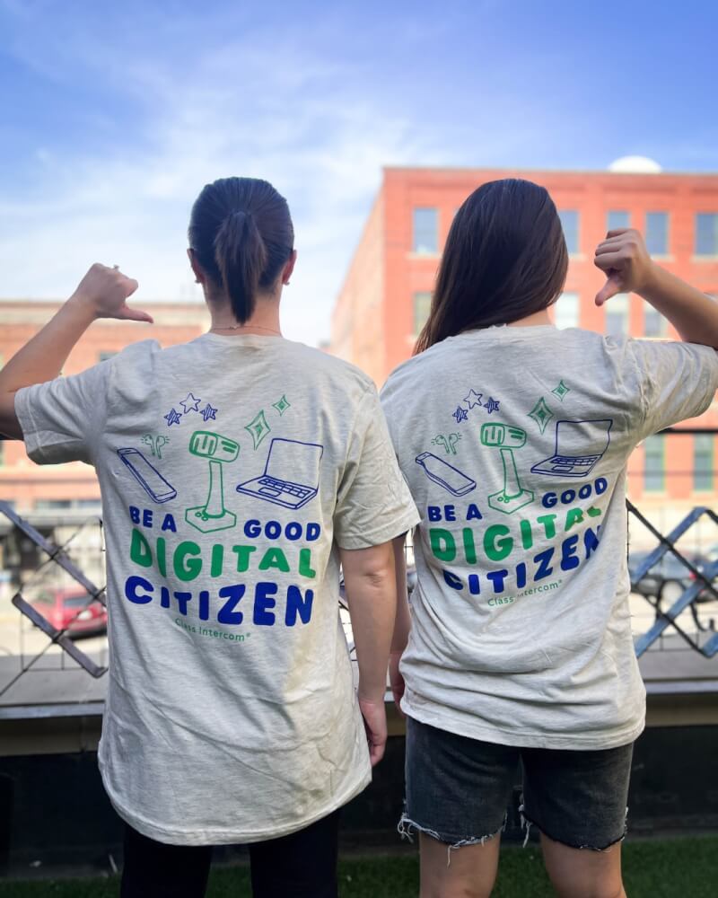 Two people wearing Class Intercom “Be a Good Digital Citizen” shirts, promoting digital responsibility in schools.