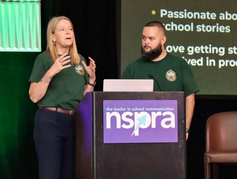 Two presenters in Camp Create shirts speaking from a podium bearing the NSPRA logo.