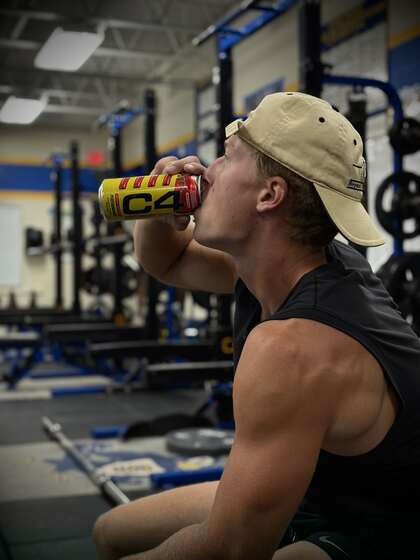 Kalen taking a break during a workout with a C4 energy drink, one of the NIL brand partnerships he has built through his personal content.